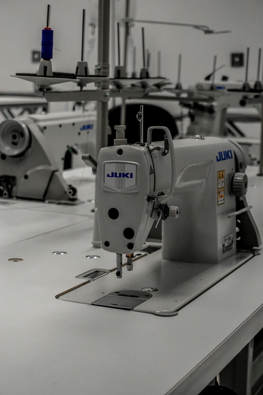 Close-up of an industrial sewing machine in a well-equipped textile workshop.